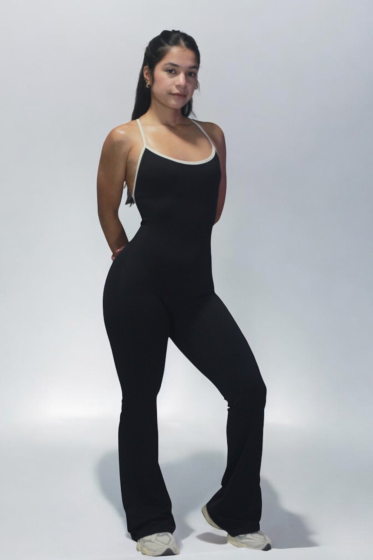 Woman wearing a black jumpsuit on a white background