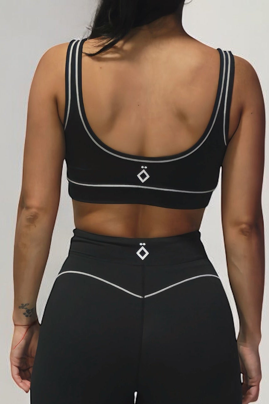 Black leggings with white accents worn by a person on a light gray background