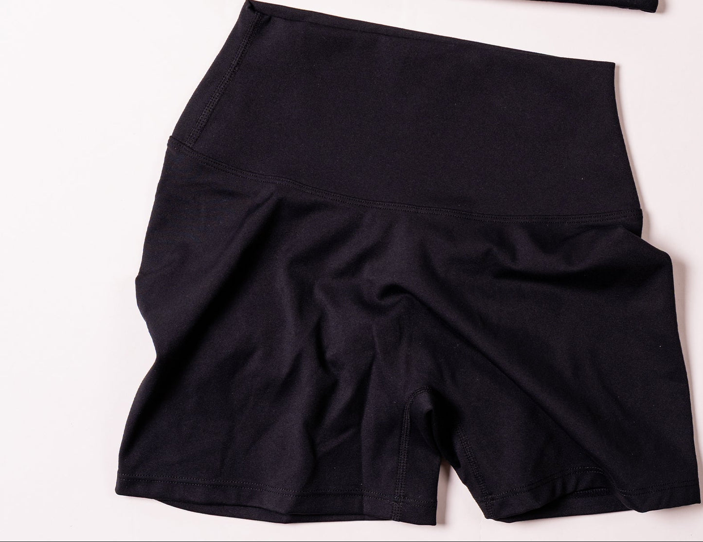 Black activewear set with cross-back sports bra and ruched sculpt shorts