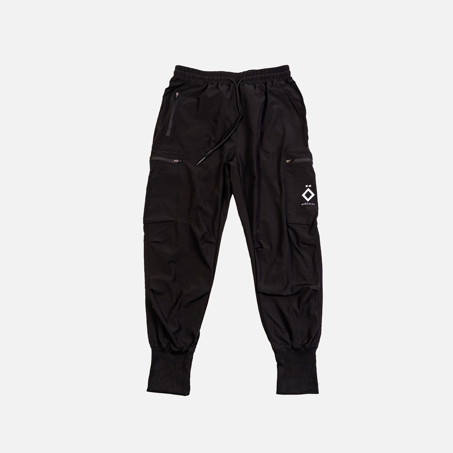Black jogger pants with zippers and a logo on a light gray background